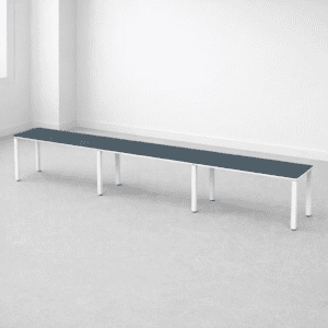 Mesa larga de oficina con superficie gris oscuro y estructura blanca para espacios laborales.