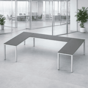 Mesa de oficina moderna en espacio abierto con plantas decorativas.