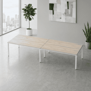 Mesa de oficina moderna y minimalista en espacio luminoso con plantas decorativas.
