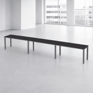 Mesa larga de oficina moderna en espacio luminoso y minimalista.