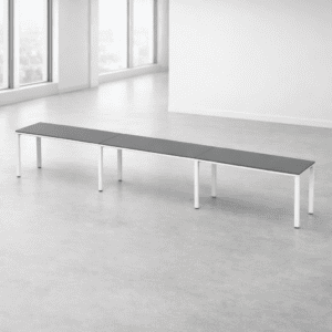 Mesa larga de oficina moderna y funcional en espacio luminoso y minimalista.