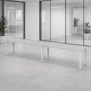 Banca larga en oficina moderna con paredes de vidrio y plantas decorativas. Espacio de trabajo abier.