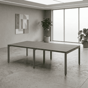 Mesa de oficina moderna en espacio minimalista con plantas y arte en la pared.