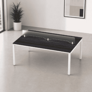 Mesa de oficina con barrera de acrílico para protección en espacios laborales.